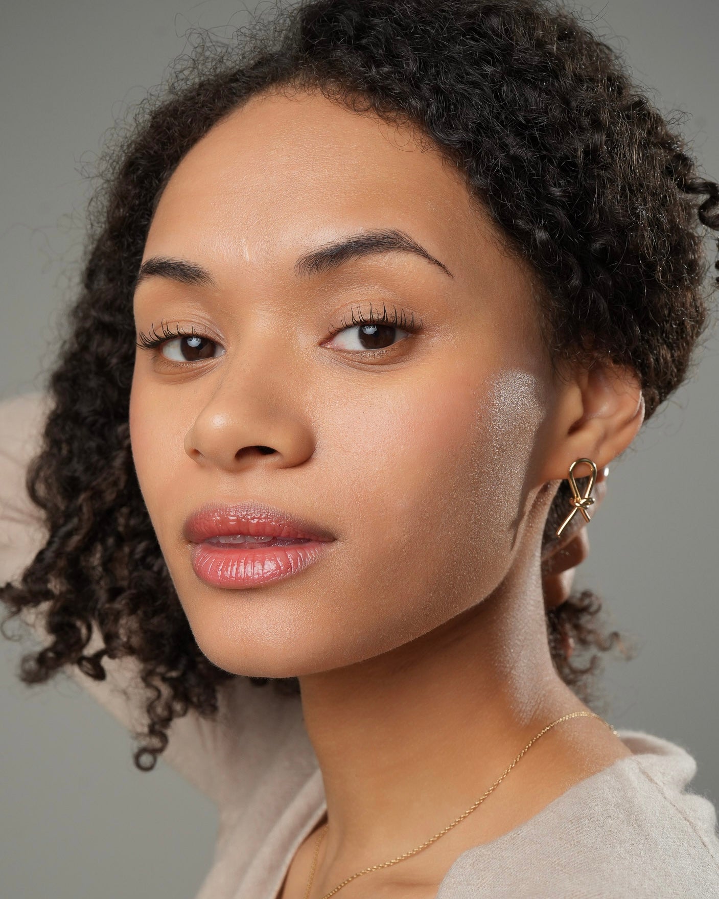 Gold knot stud earrings in 18k gold plating 3 microns worn by model front view