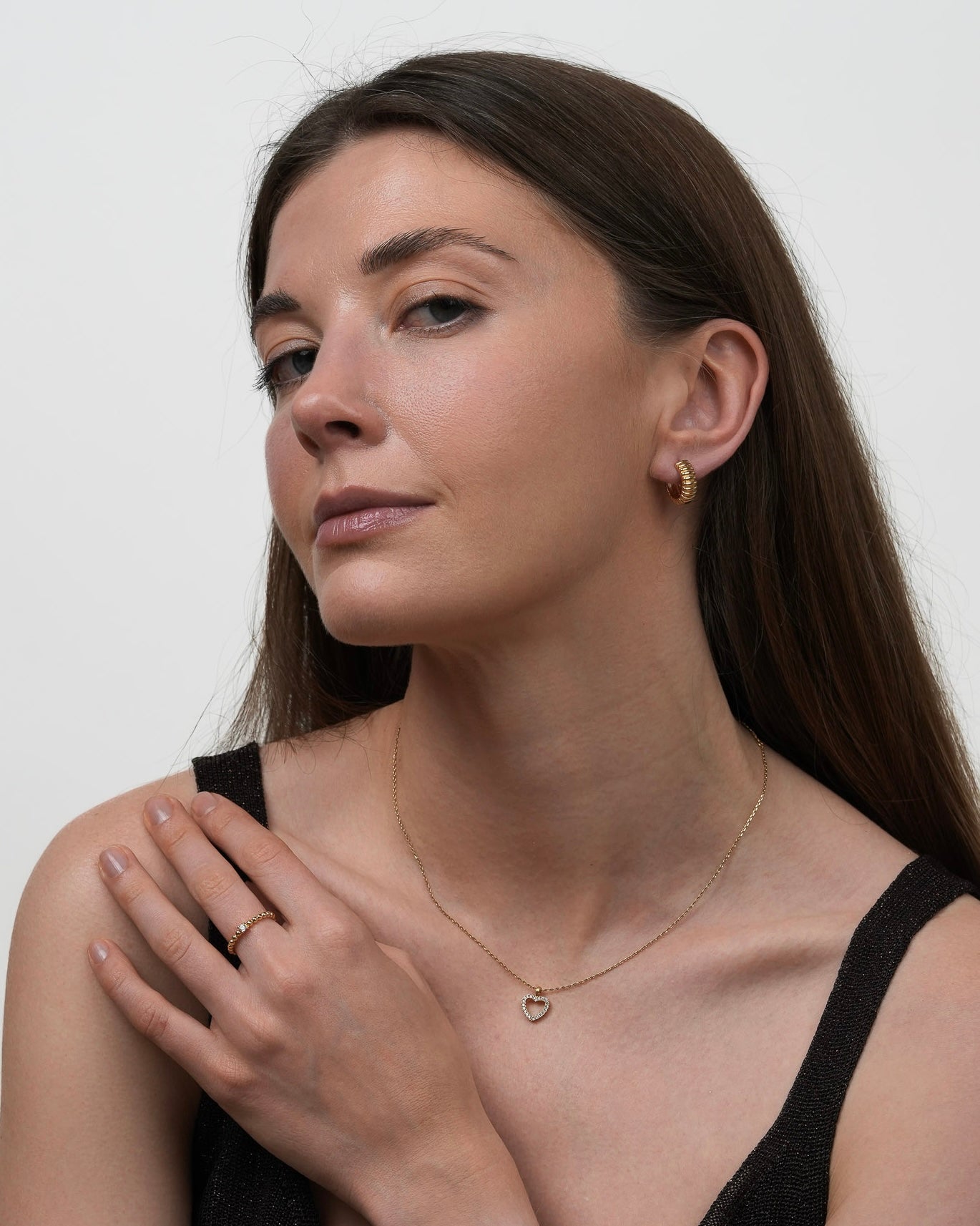 Woman wearing gold plated small ribbed hoop earrings