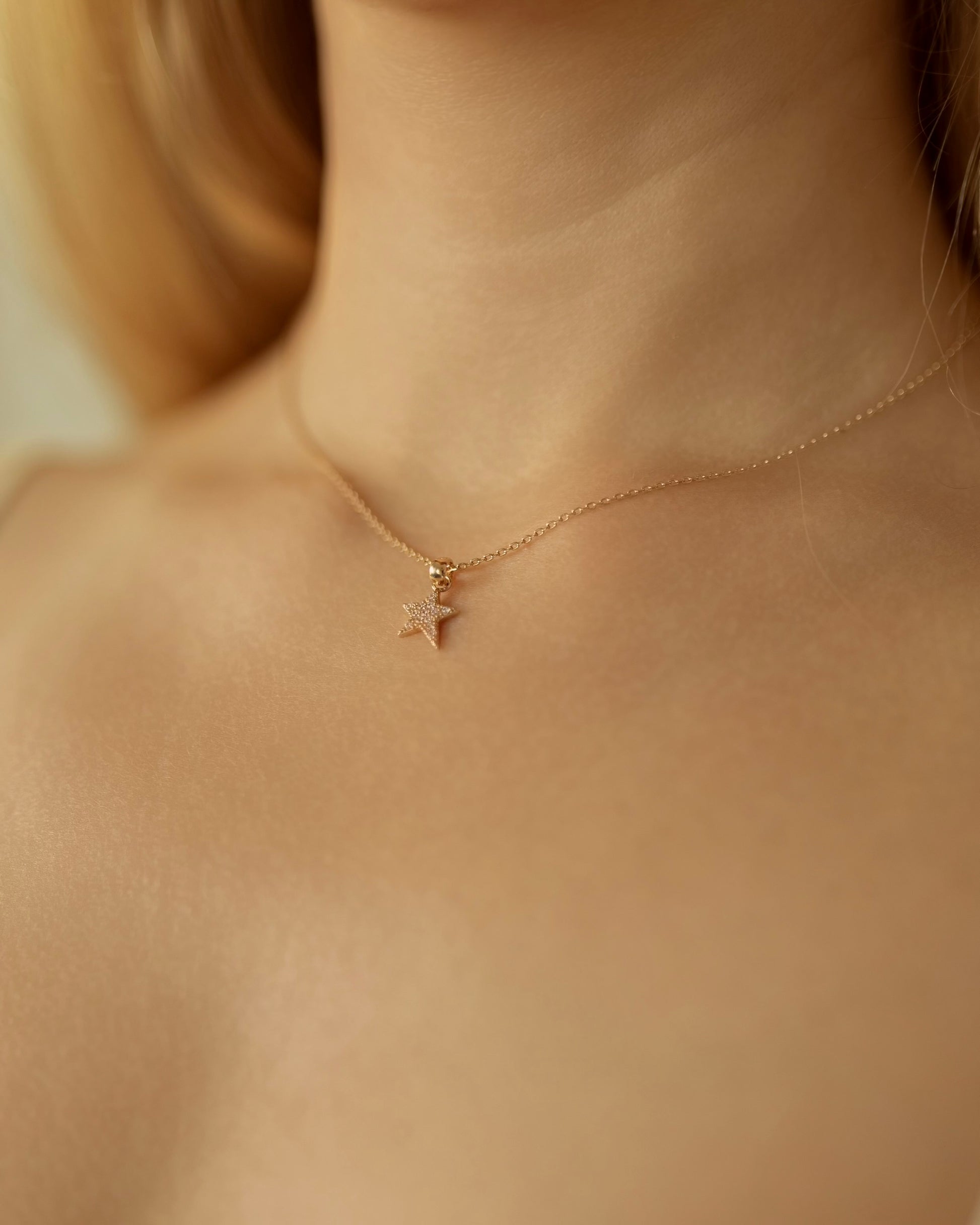 Necklace with a star pendant worn by a person