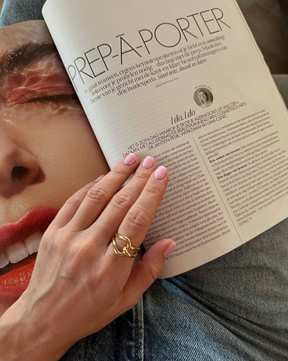 Hand with a gold ring holding an open magazine