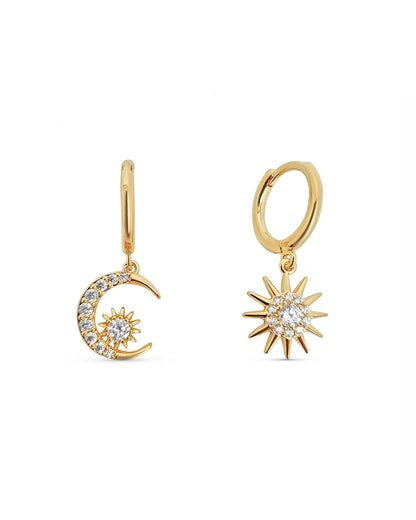 Gold earrings shaped like a moon and a sun with a cm ruler on the side.