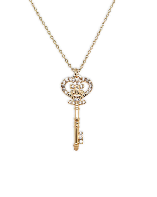 Gold key-shaped pendant necklace on a white background