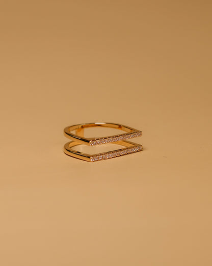 Gold ring with a subtle design on a beige background