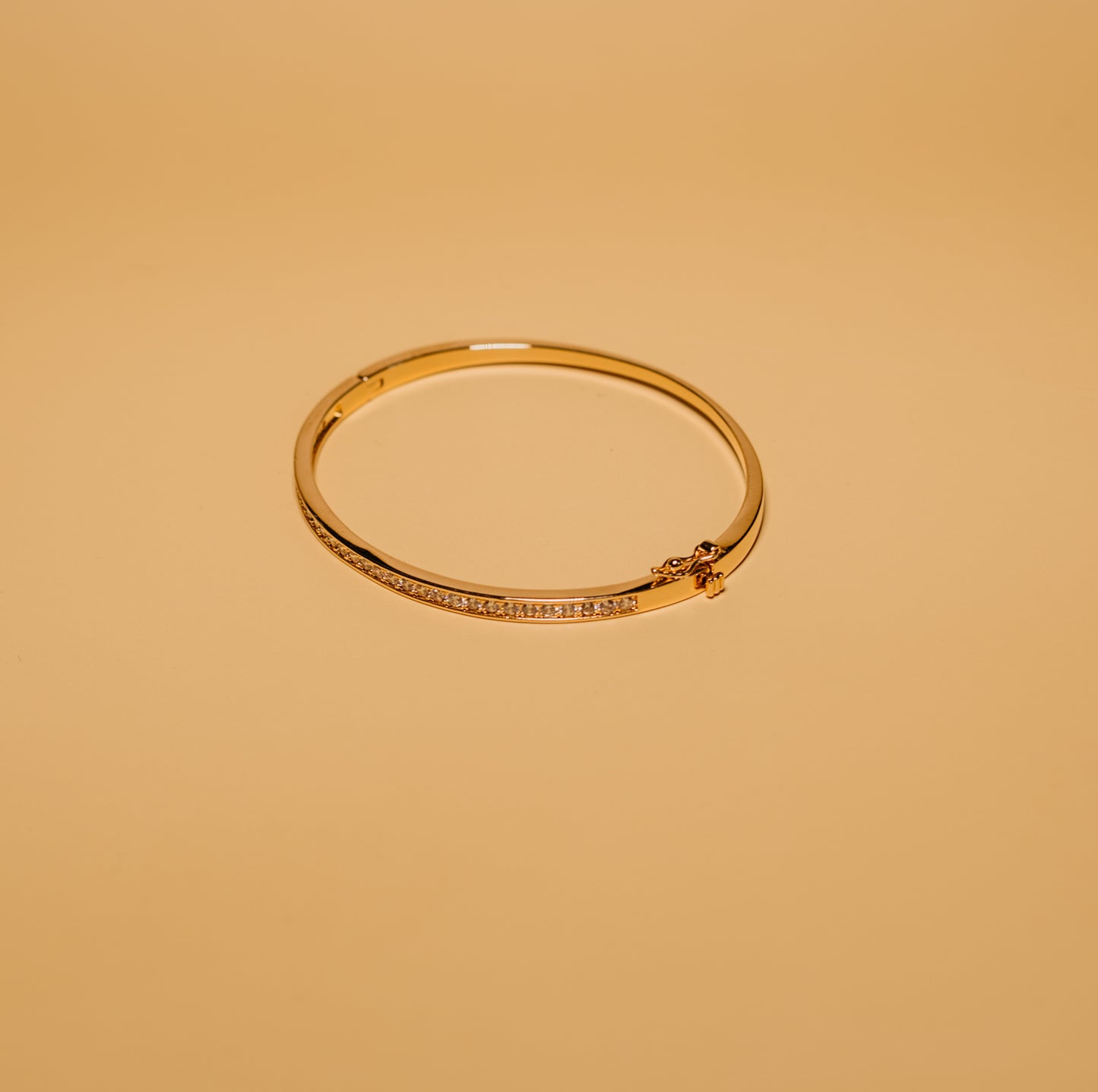 Gold bracelet on a beige background