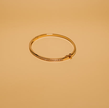 Gold bracelet on a beige background