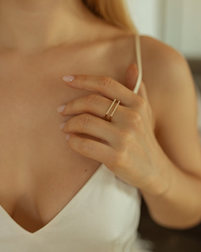 Close-up of a hand wearing a gold ring on a blurred background