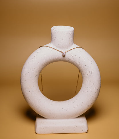 White ceramic ring-shaped vase on a beige background
