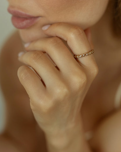 Close-up of a hand with a gold ring with stones
