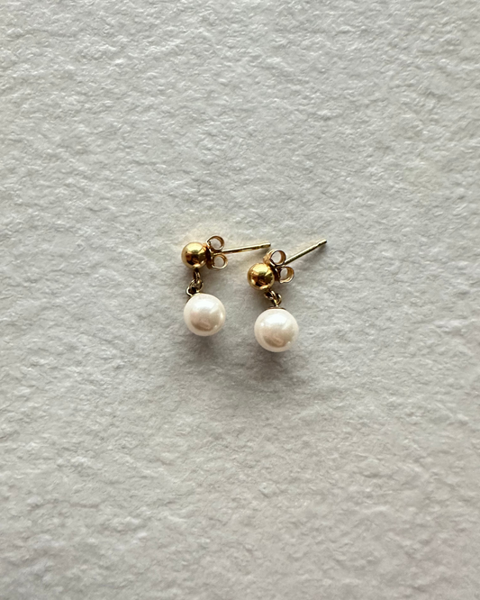 Pair of pearl earrings on a light gray background