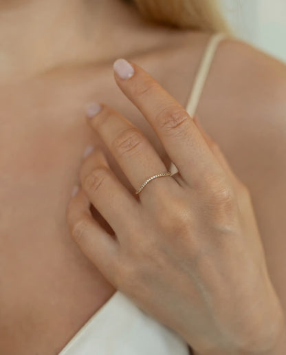 Gold plated band ring with cuboc zirconia stones in natural light, minimalist style