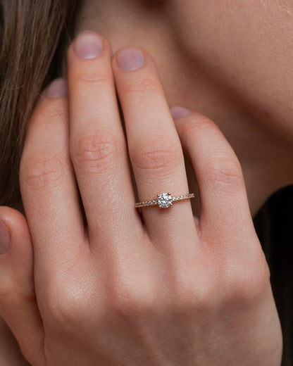 Gold plated solitaire ring with pavé band worn on hand lifestyle portrait
