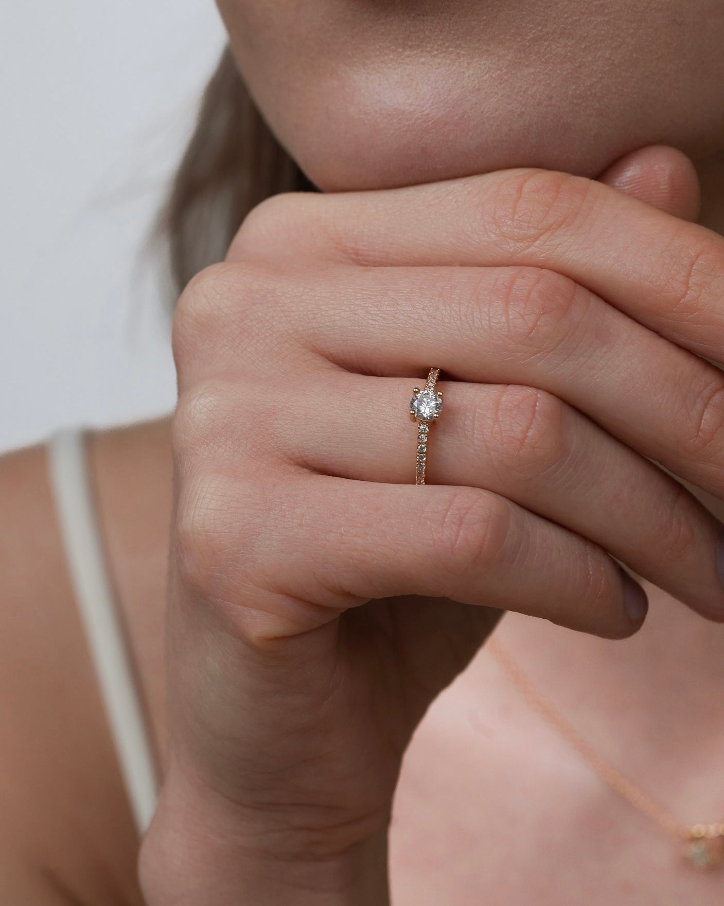 Gold plated solitaire ring with round cubic zirconia worn on hand close-up