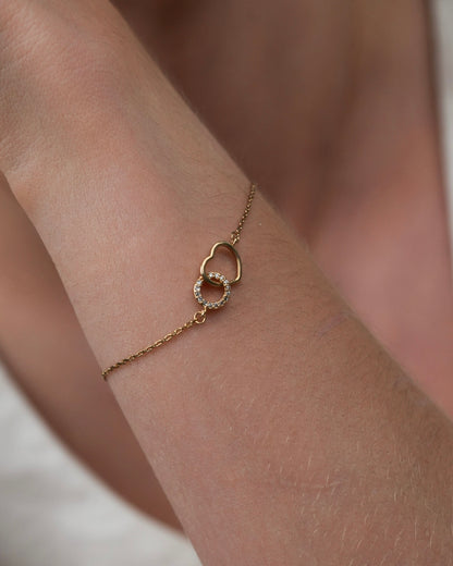 Gold plated heart bracelet with cubic zirconia worn on wrist close-up detail
