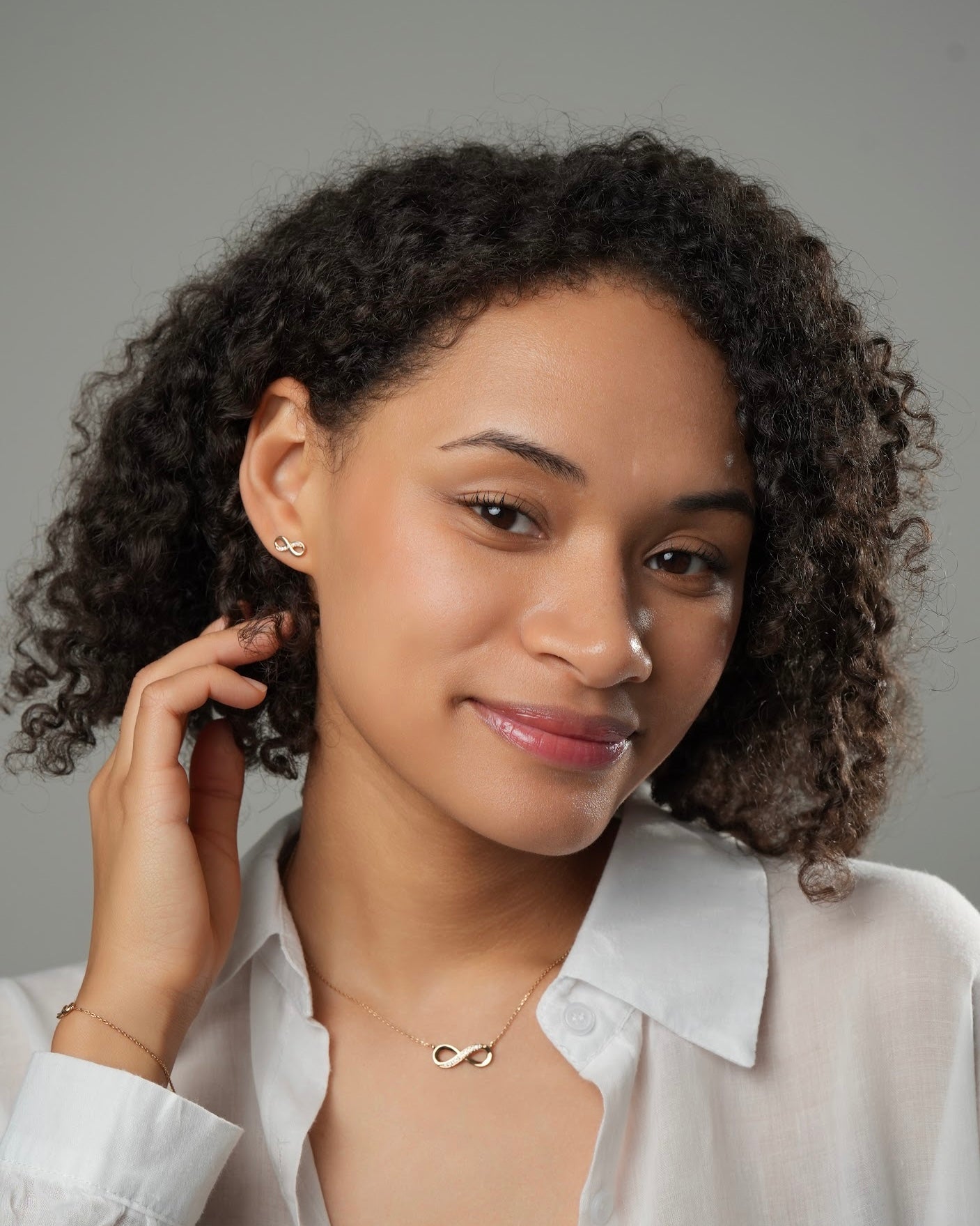 Infinity stud earrings LIA gold plated 18k 3 microns with cubic zirconia, minimalist stud earrings with infinity necklace, front view