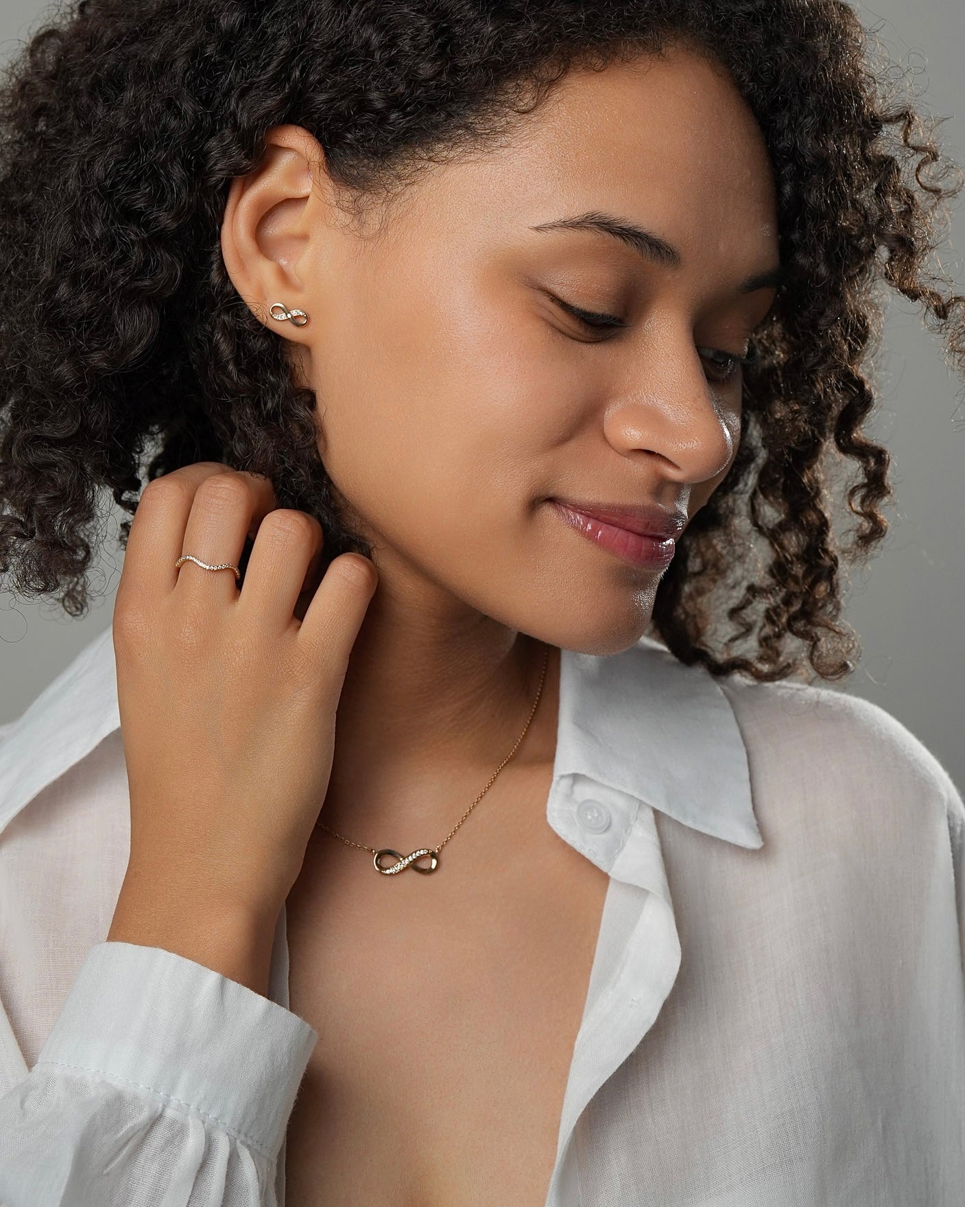 Infinity pendant necklace worn as a daily jewelry piece in 18k gold plated finish