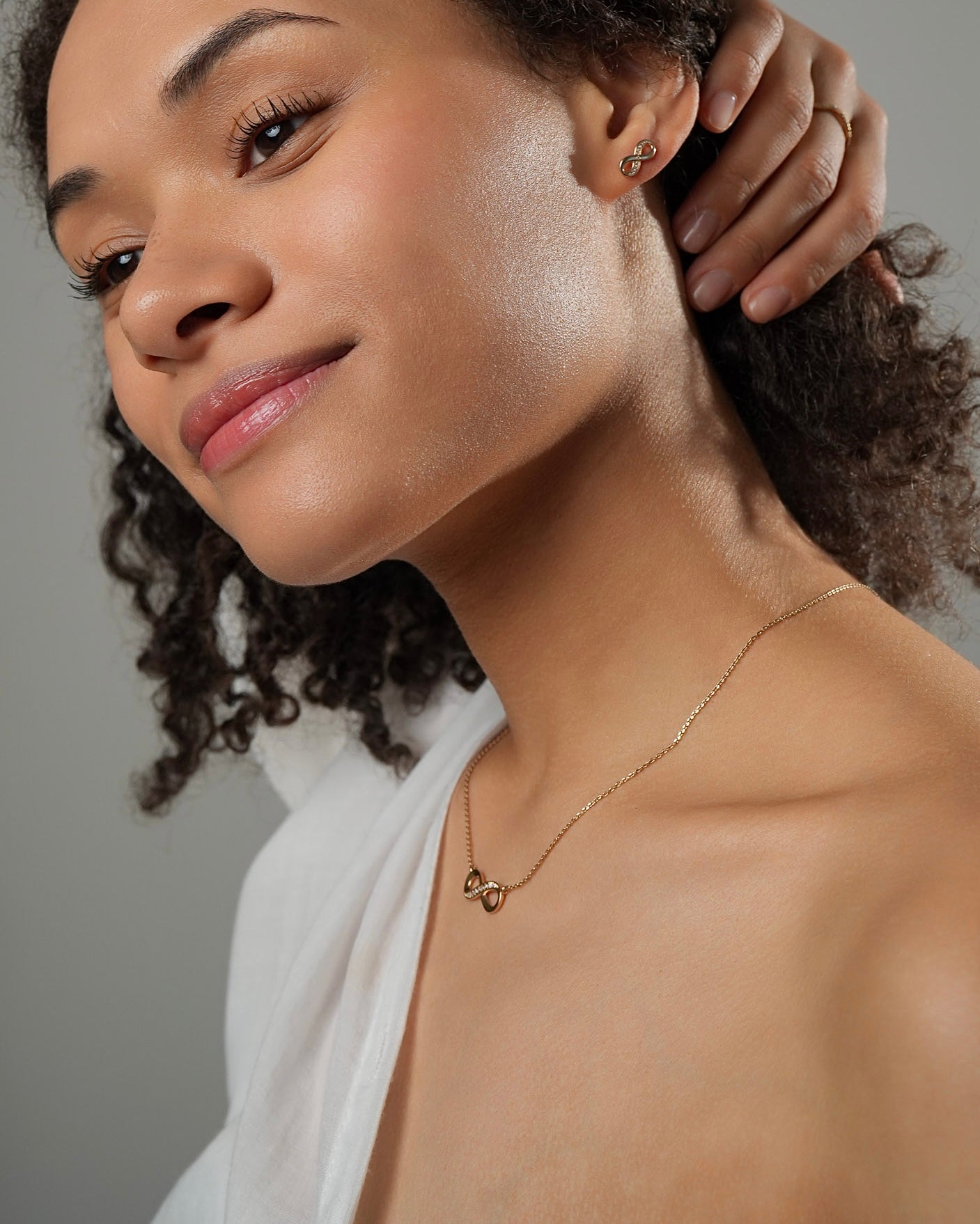 Infinity pendant necklace with cubic zirconia stones on the neck