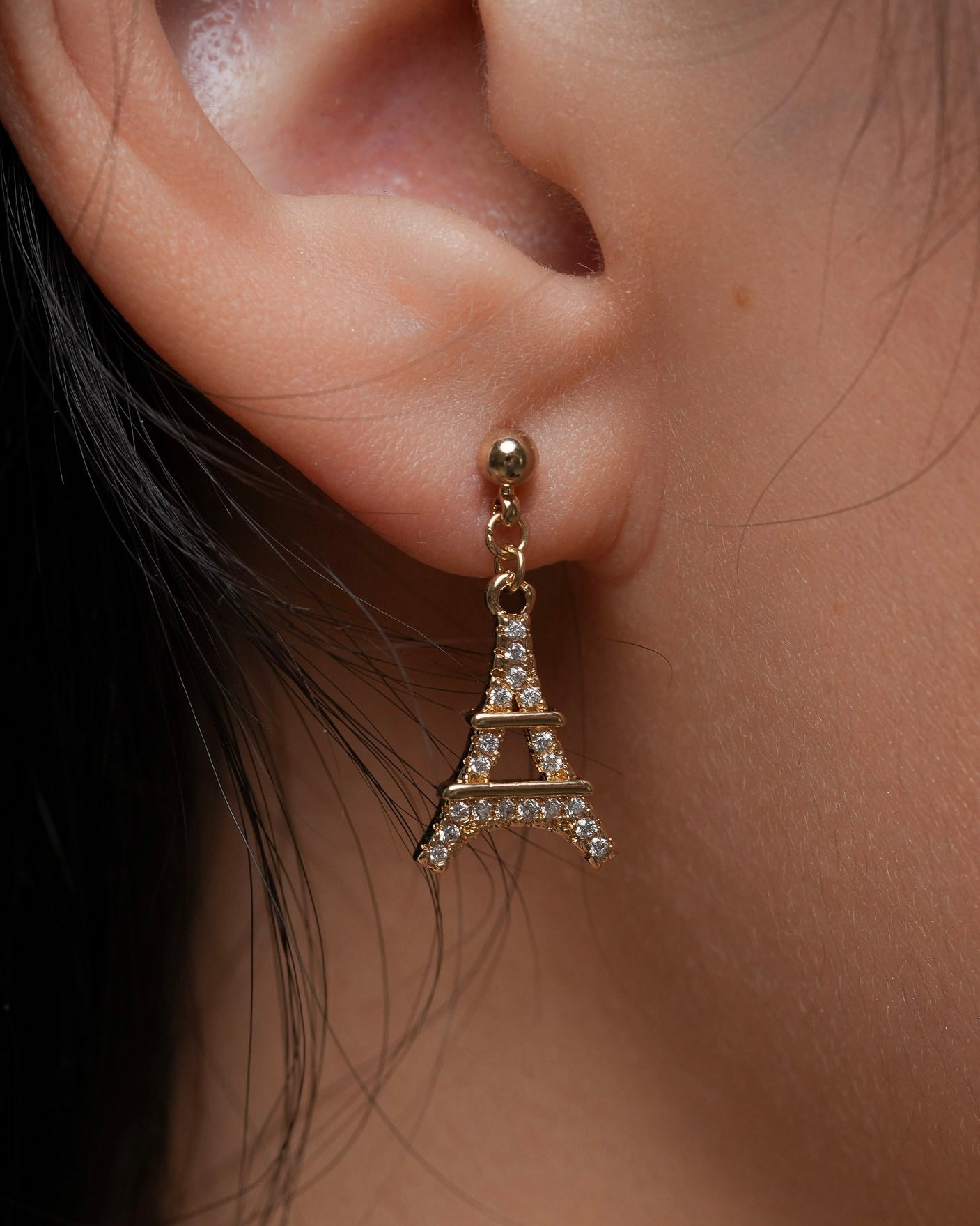 Eiffel Tower dangle earrings in 18K gold plating worn on ear