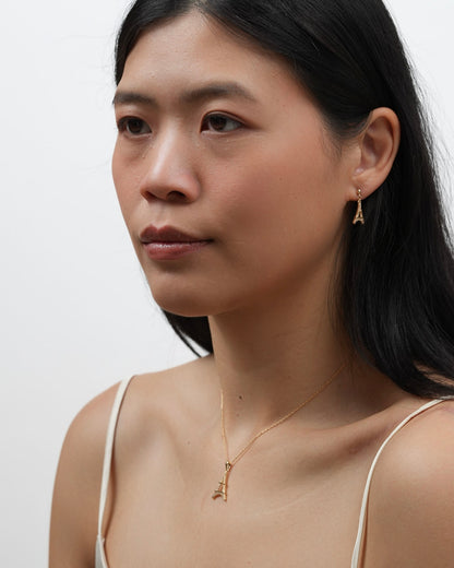 Model wearing gold plated Eiffel Tower dangle earrings with matching necklace